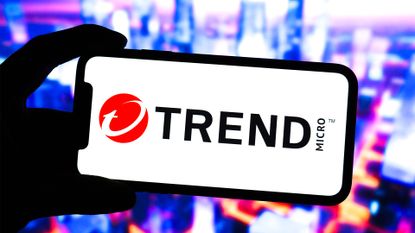 Trend Micro logo and branding pictured on a smartphone screen with cityscape pictured in background.