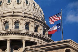 U.S. and Texas flags over Texas Capitol
