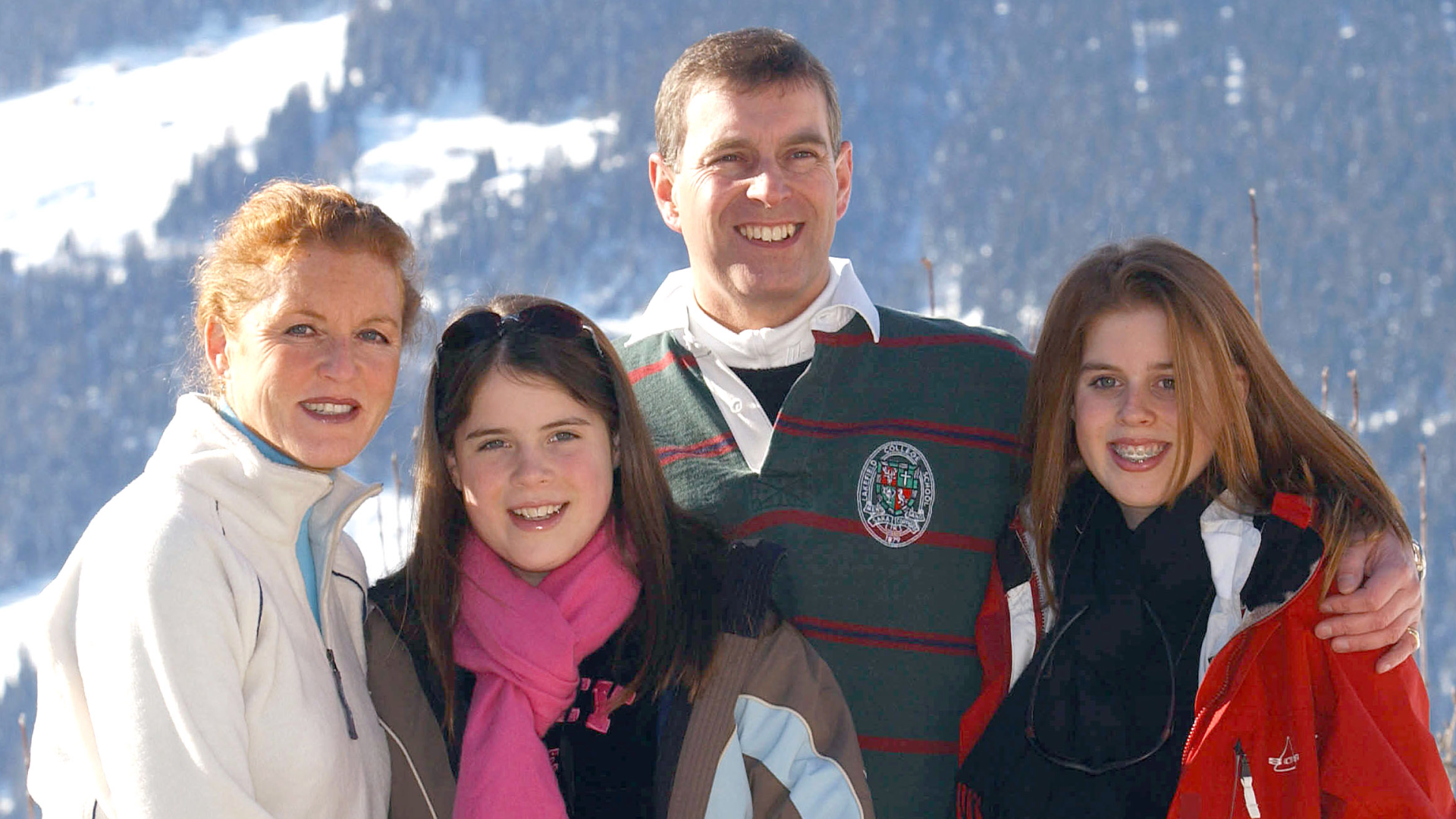 Sarah Ferguson, Prince Andrew, Princess Beatrice and Princess Eugenie posing in front of a snowy mountain in 2003