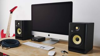 KRK monitors on a desk next to a Mac