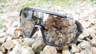 A pair of mirrored glasses on a pile of pebbles