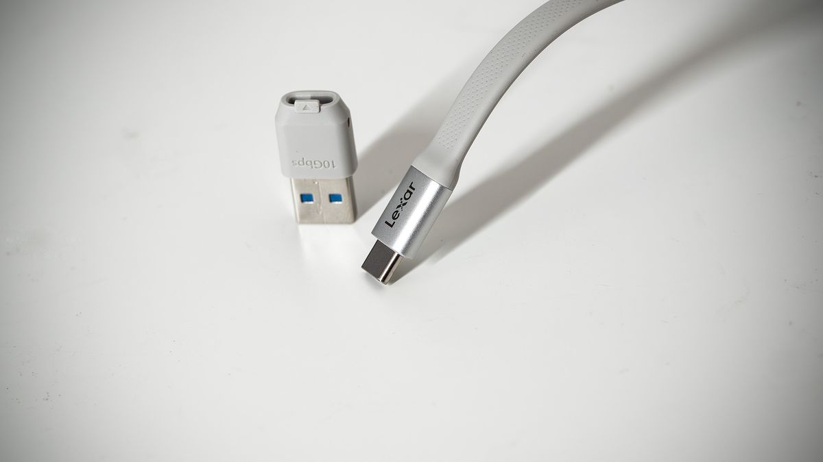 Lexar TouchLock Portable SSD on a white table with a phone.