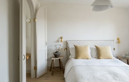 A neutral bedroom with a bed in the center of the space