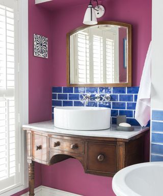bathroom with wooden table and pink with blue tiled wall