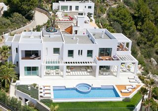 aerial view of villa and swimming pool with white wall