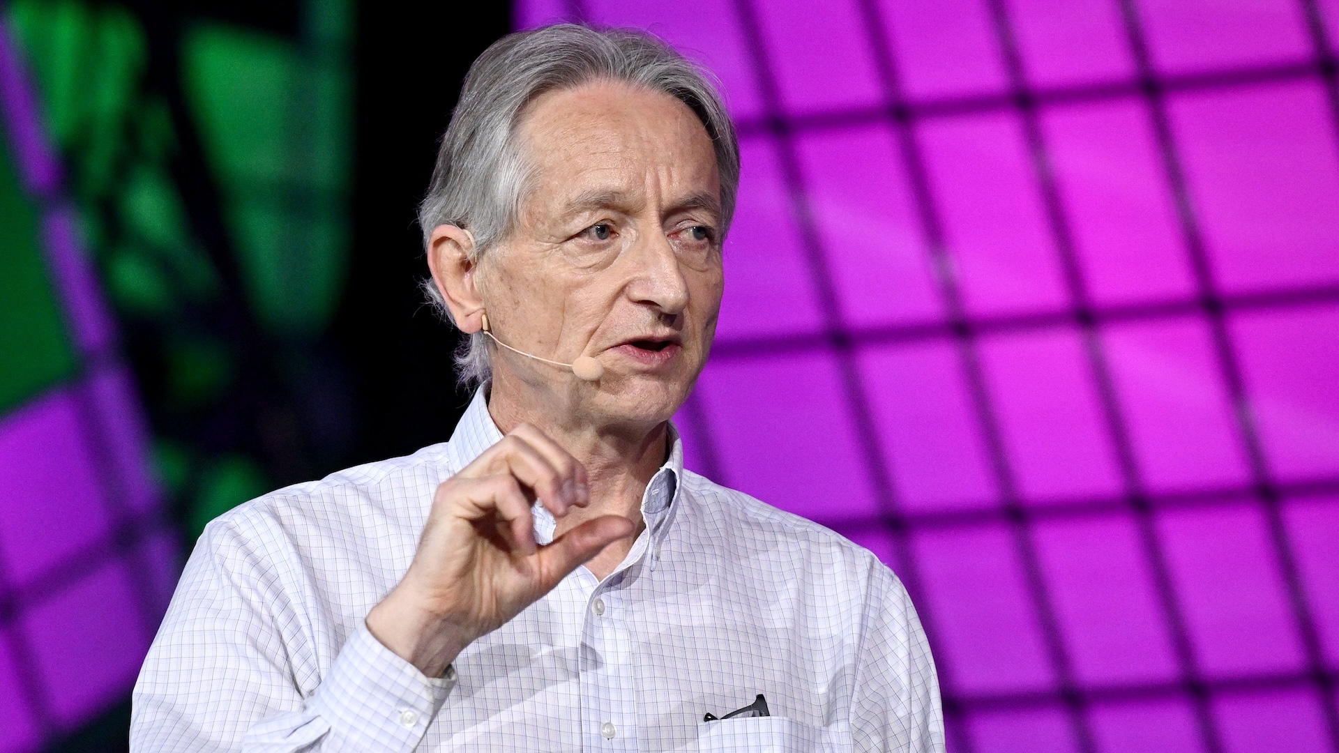 A photo of Geoffrey Hinton speaking at a conference in 2023