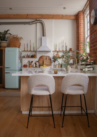industrial style boho kitchen with mint smeg fridge and white textured bar stools