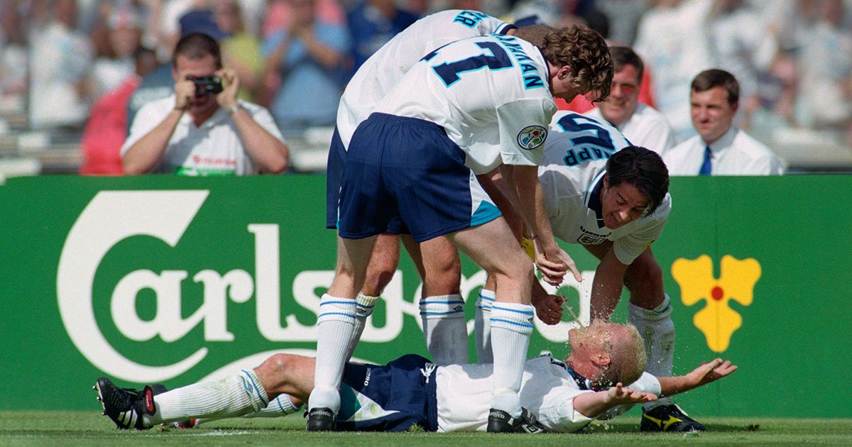 England goalscorer Paul Gascoigne celebrates in the &#039;Dentists Chair&#039; with Steve McManaman (l) Alan Shearer (obscured) and Jamie Redknapp during the 1996 European Championships group stage match against Scotland at Wembley Stadium on June 15, 1996 in London, England.