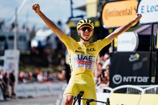 Tadej Pogacar celebrates victory after a record-breaking ride up Plateau de Beille