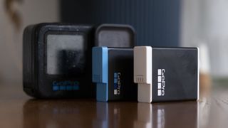 Two GoPro batteries in front of a Hero action cam