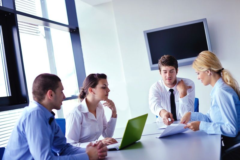 A group of colleagues meet in an office.