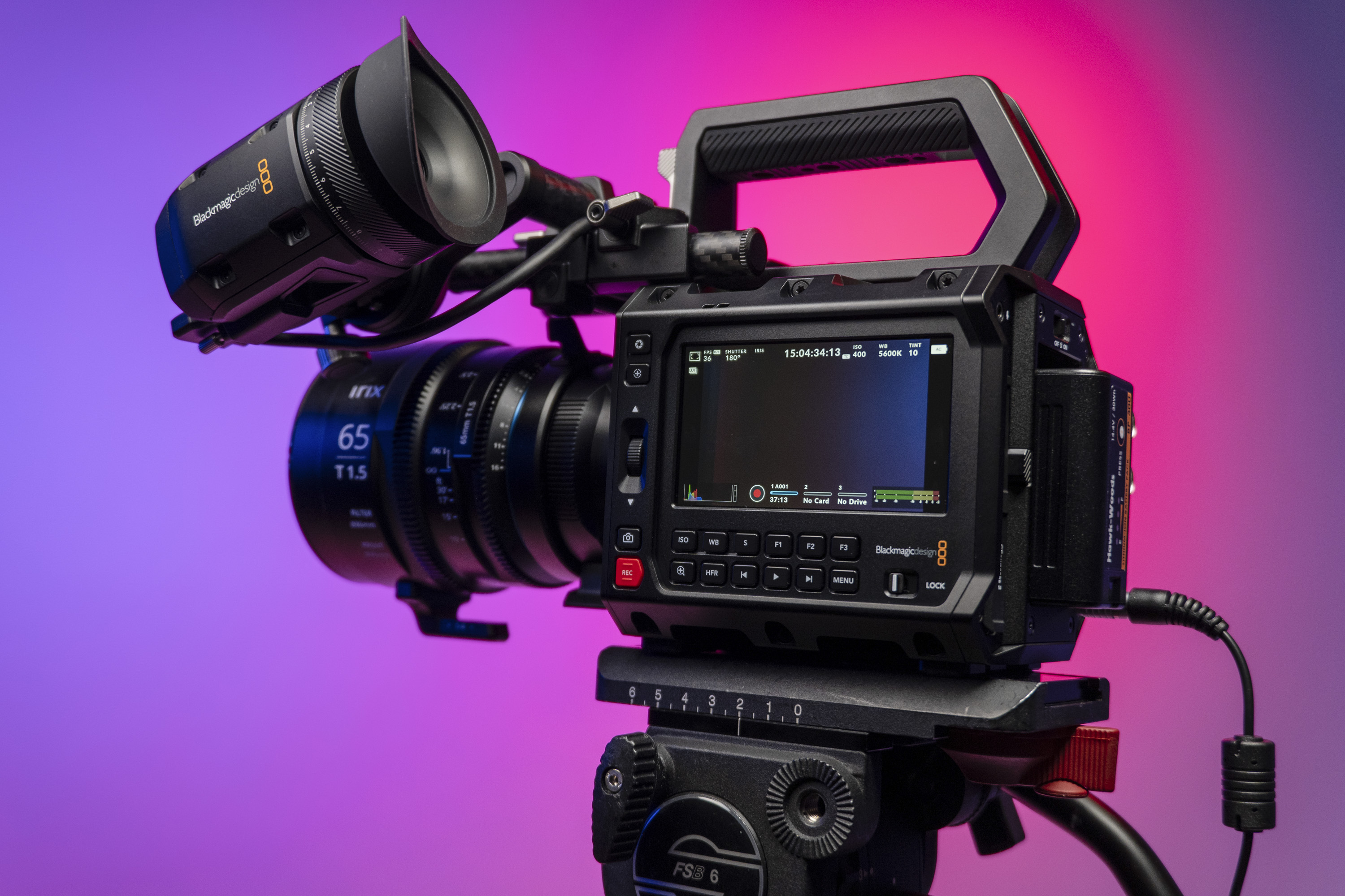 Blackmagic Pyxis 6K camera in the studio, mounted to video tripod, with a vibrant magenta background