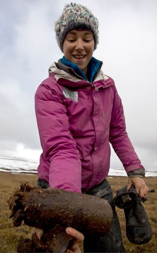 Laurel Lynch, a graduate student at the Natural Resource Ecology Laboratory at Colorado State University, shows off a perfectly intact soil core collected from Arctic Tundra.