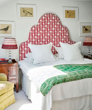 bedroom with red patterned headboard, green throw and yellow chair