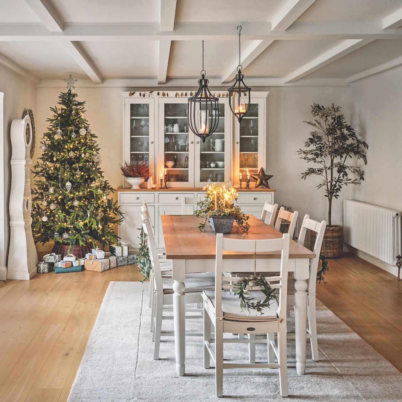 Rustic, tidy dining room with a decorated Christmas tree and presents.