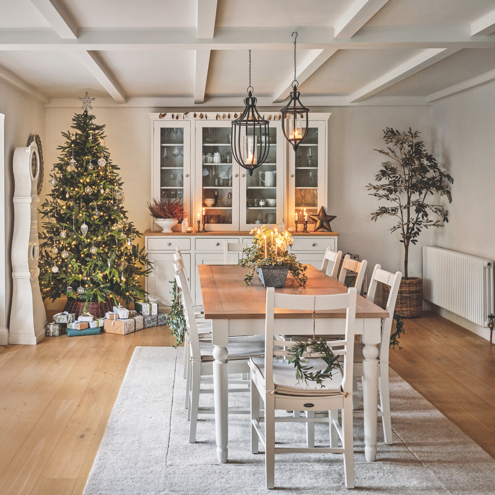 Rustic, tidy dining room with a decorated Christmas tree and presents.
