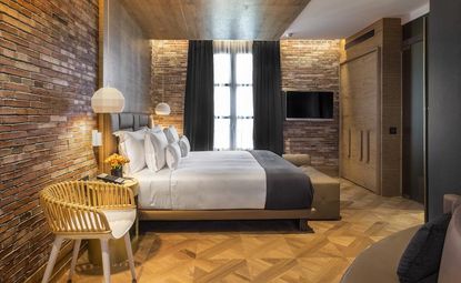 Hotel guest room features wooden floors and exposed brick
