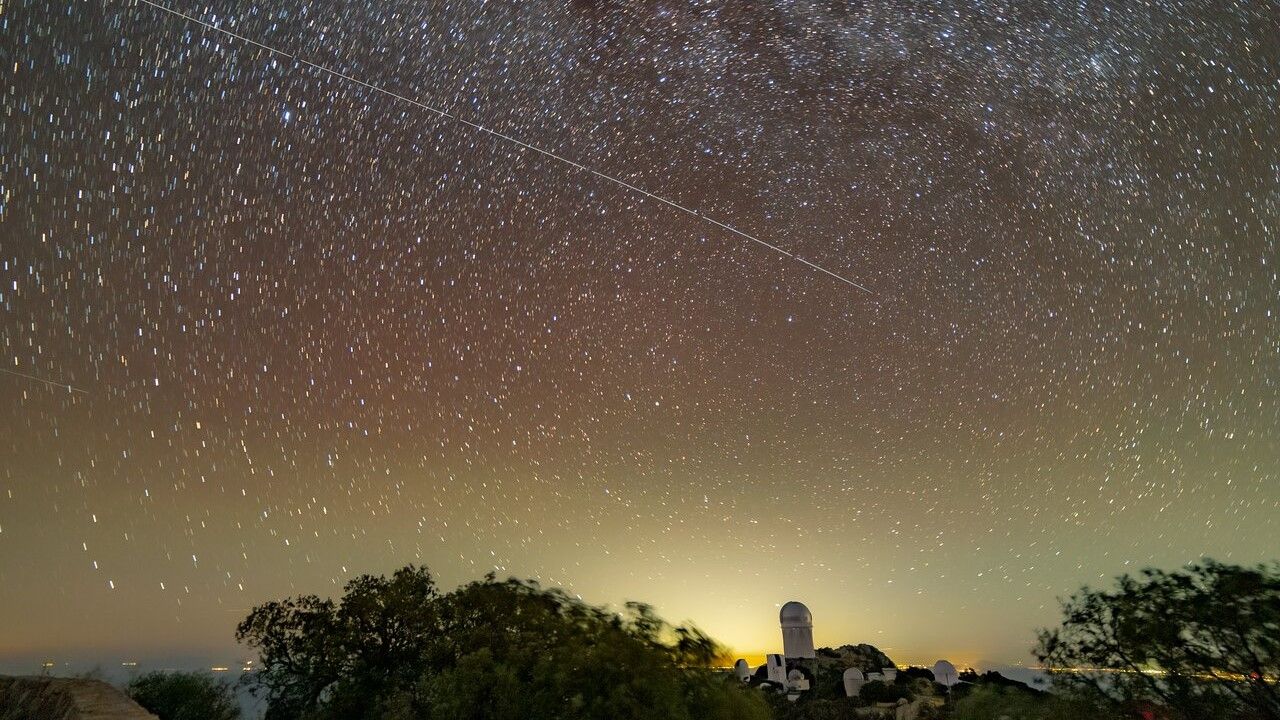 Trails in the night sky left by BlueWalker 3 are juxtaposed against the Nicholas U. Mayall 4-meter Telescope at Kitt Peak National Observatory