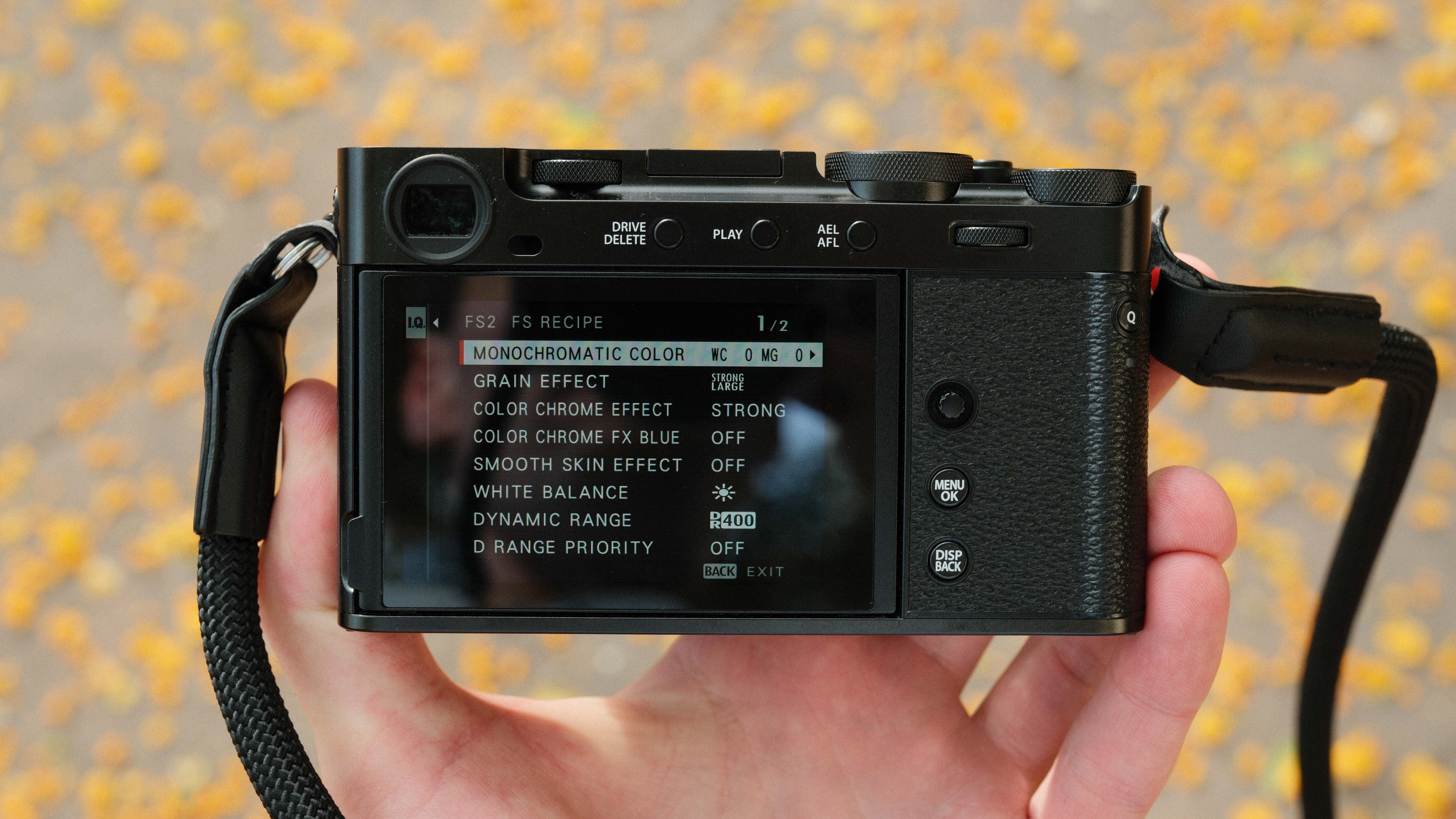 Fujifilm X-E5 camera held in a hand showing settings on the rear screen