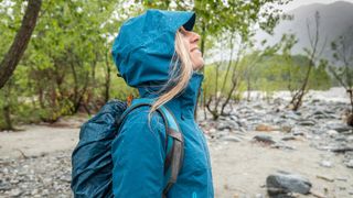 Hiker wearing waterproof jacket with hood up