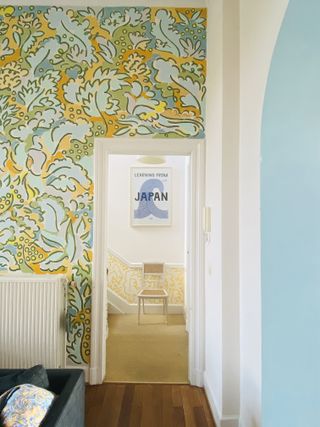 View through to hallway with bold wallpaper by Claire de Quénetain