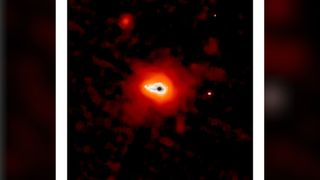 A glowing dark dot surrounding by blobs of white, orange and red light sits on a dark background