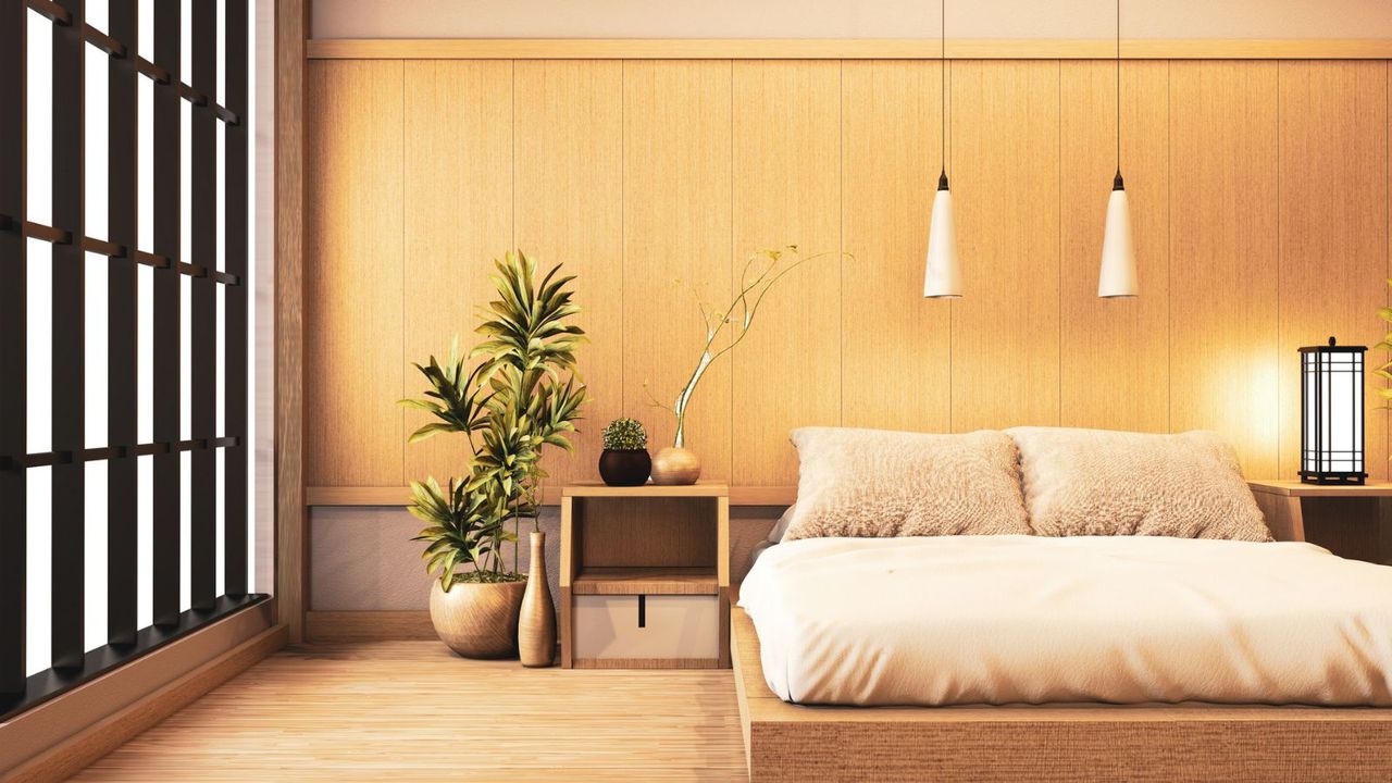 A minimalist bed frame against a gold wall on a hardwood floor.