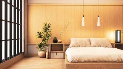 A minimalist bed frame against a gold wall on a hardwood floor.