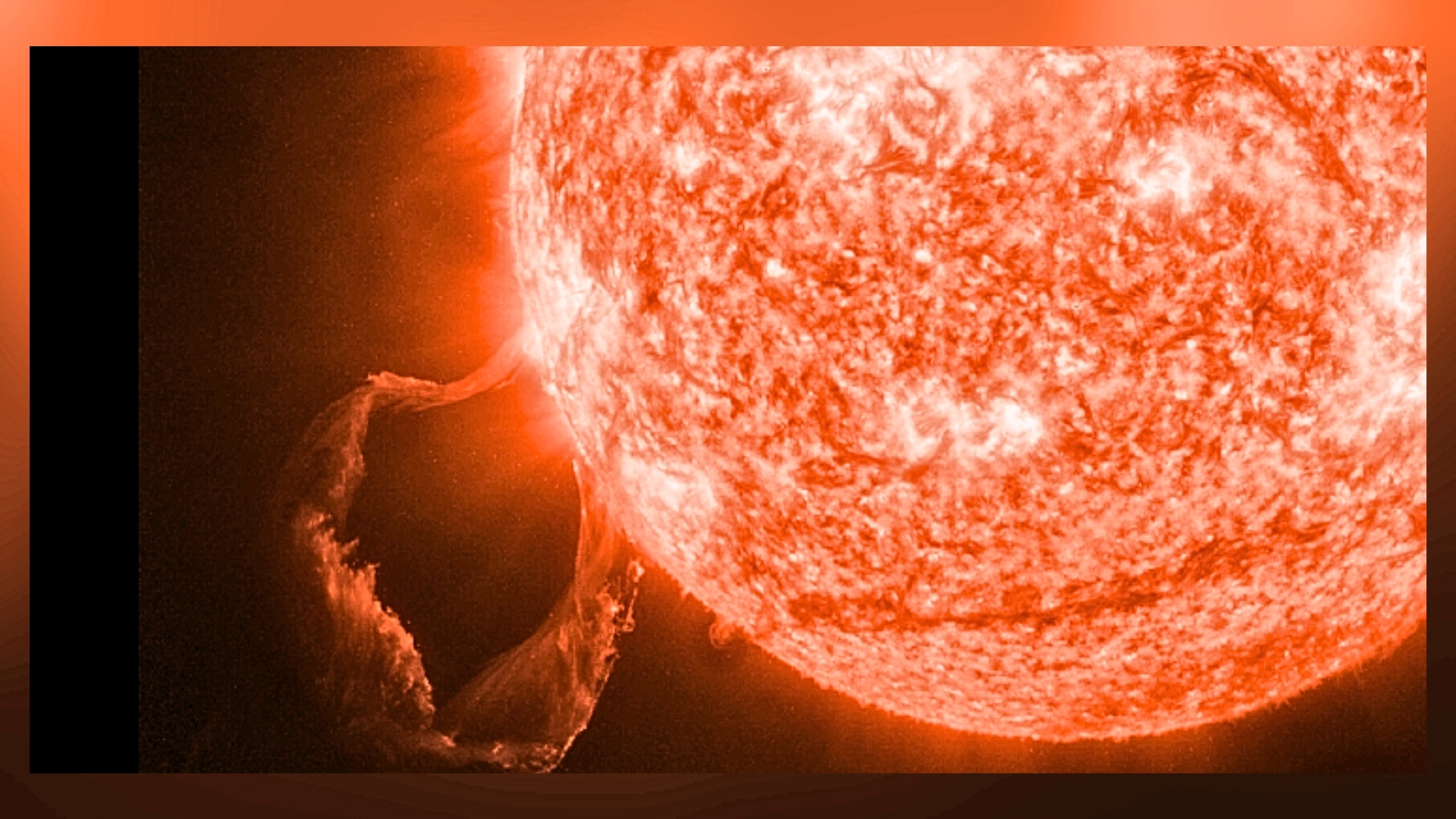 a close up view of the sun erupting with a large prominence looping in the bottom left corner of the image. 