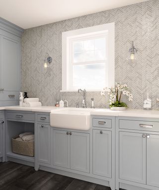 Fresh neutrals laundry room scheme with light gray cabinets, gray tiled backsplash and large ceramic utility sink