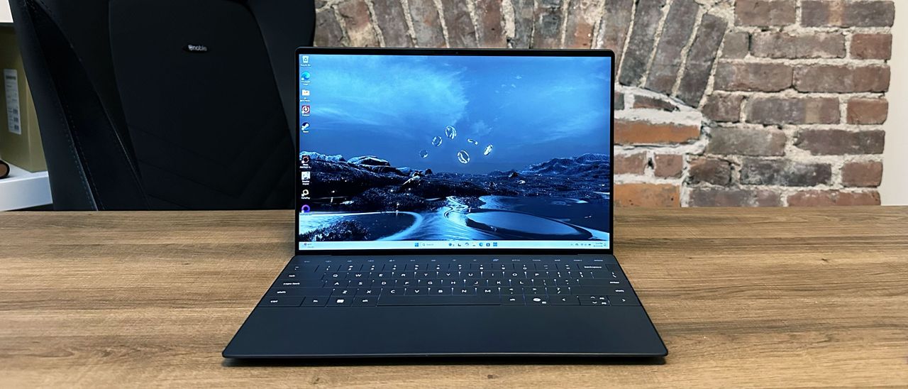 Dell XPS 13 (9350) open with the display on sitting on a wooden desk.