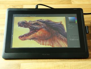 Profile shot of a Wacom Cintiq 16 on a desk with dragon artwork on the screen