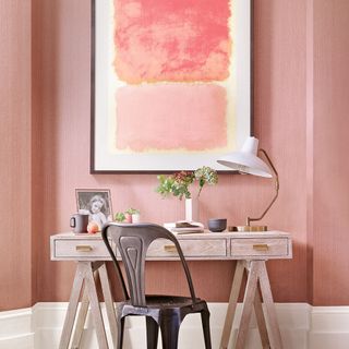 pink room with wall painting and wooden table