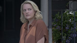 Elisabeth Moss as June sitting on the porch in The Testaments