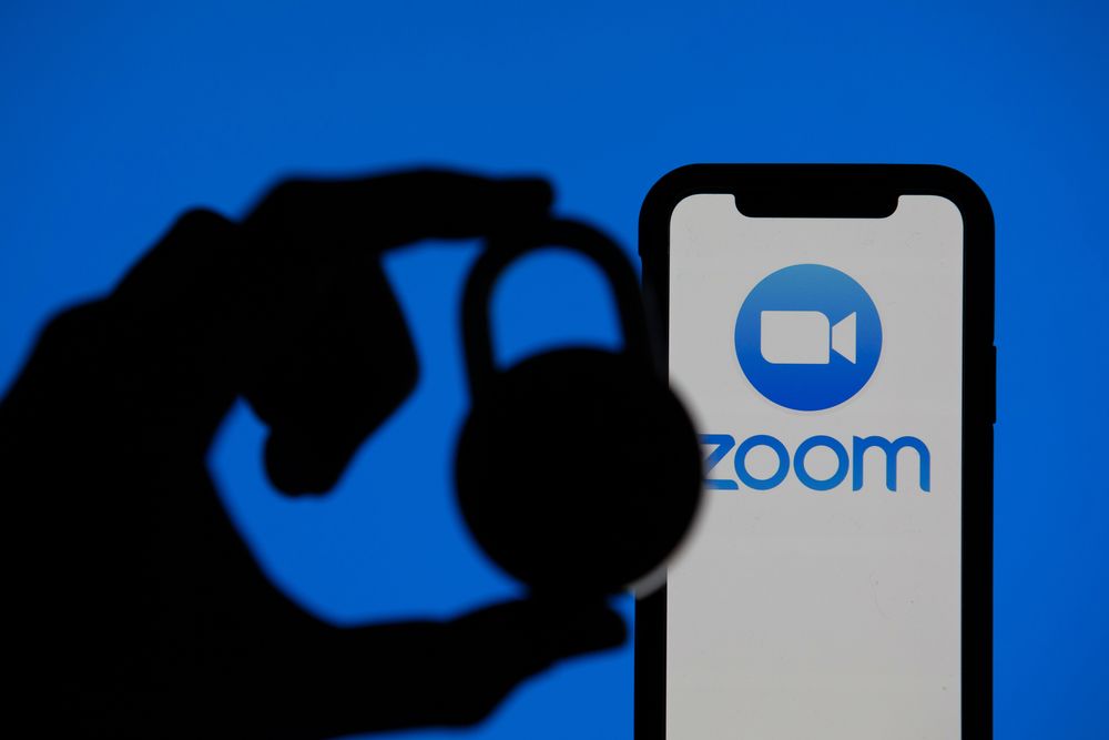  Zoom video conference app icon on a mobile device with silhouette of a padlock