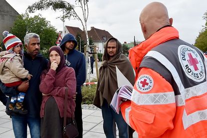 A German Red Cross worker speaks with refugees in eastern Germany.