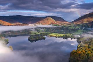 Mist burns off Lake Grasmere in the early morning, Lake District, Cumbria, England. Autumn (October) 2012.