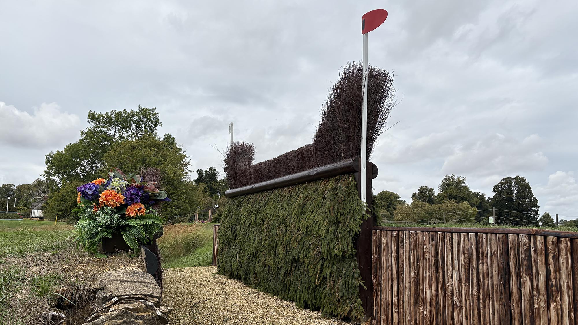 Side view of brush fence with a big ditch in front of it on the Burghley cross-country course 2026