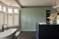 A bathroom with a walk in closet in green