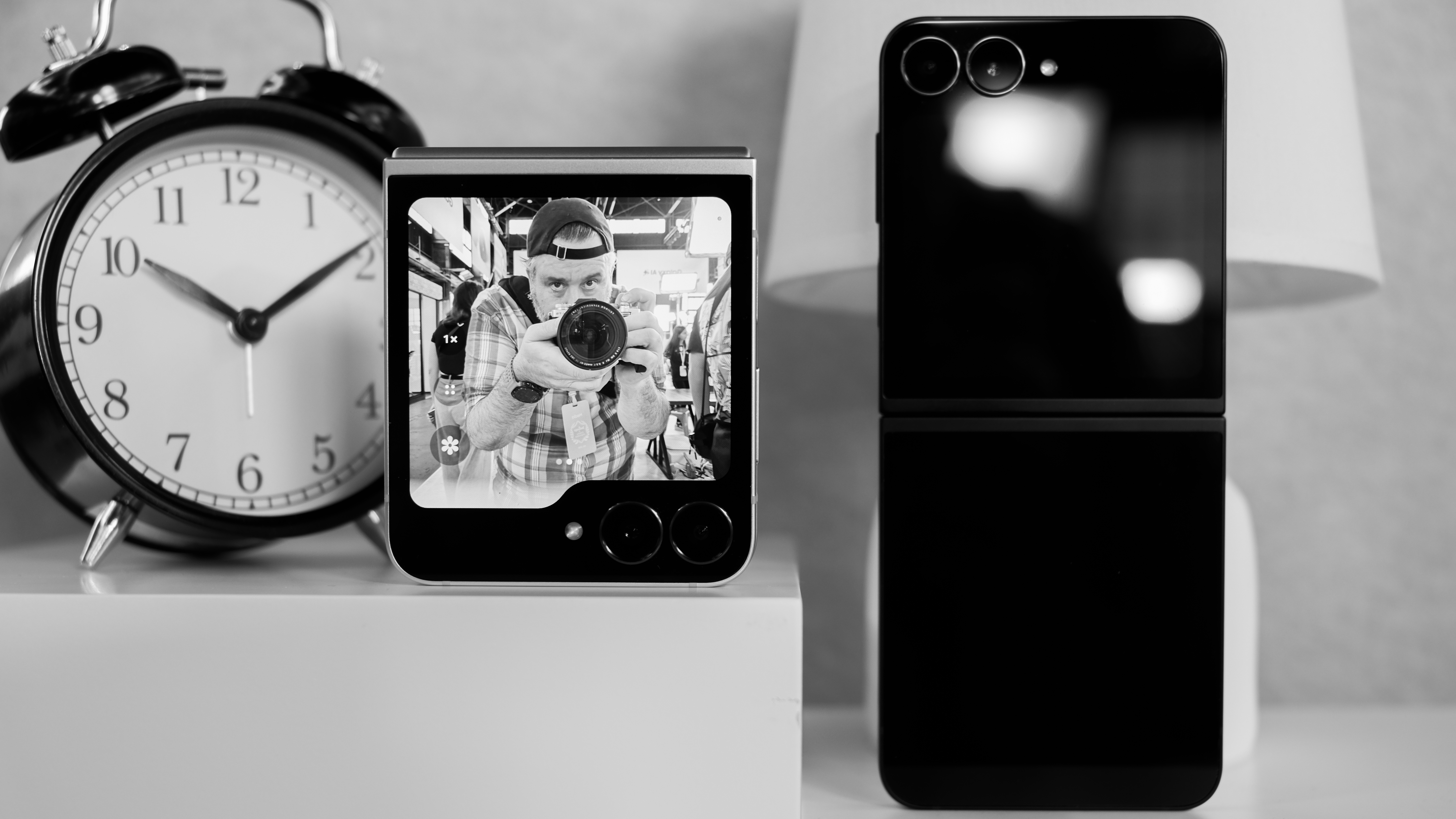 Two Samsung Galaxy Z Flip 7 FE with the cover display on one showing the camera screen with the author taking his own photo