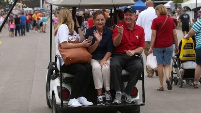 Republican presidential candidate and U.S. Sen. Lindsey Graham (R-SC) (R) (R-SC) rides on the back of a golf cart with his sister Darline Graham Nordone (C) during the Iowa State Fair 