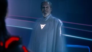 Jeff Bridges stands smiling in a white glowing robe in Tron: Ares.