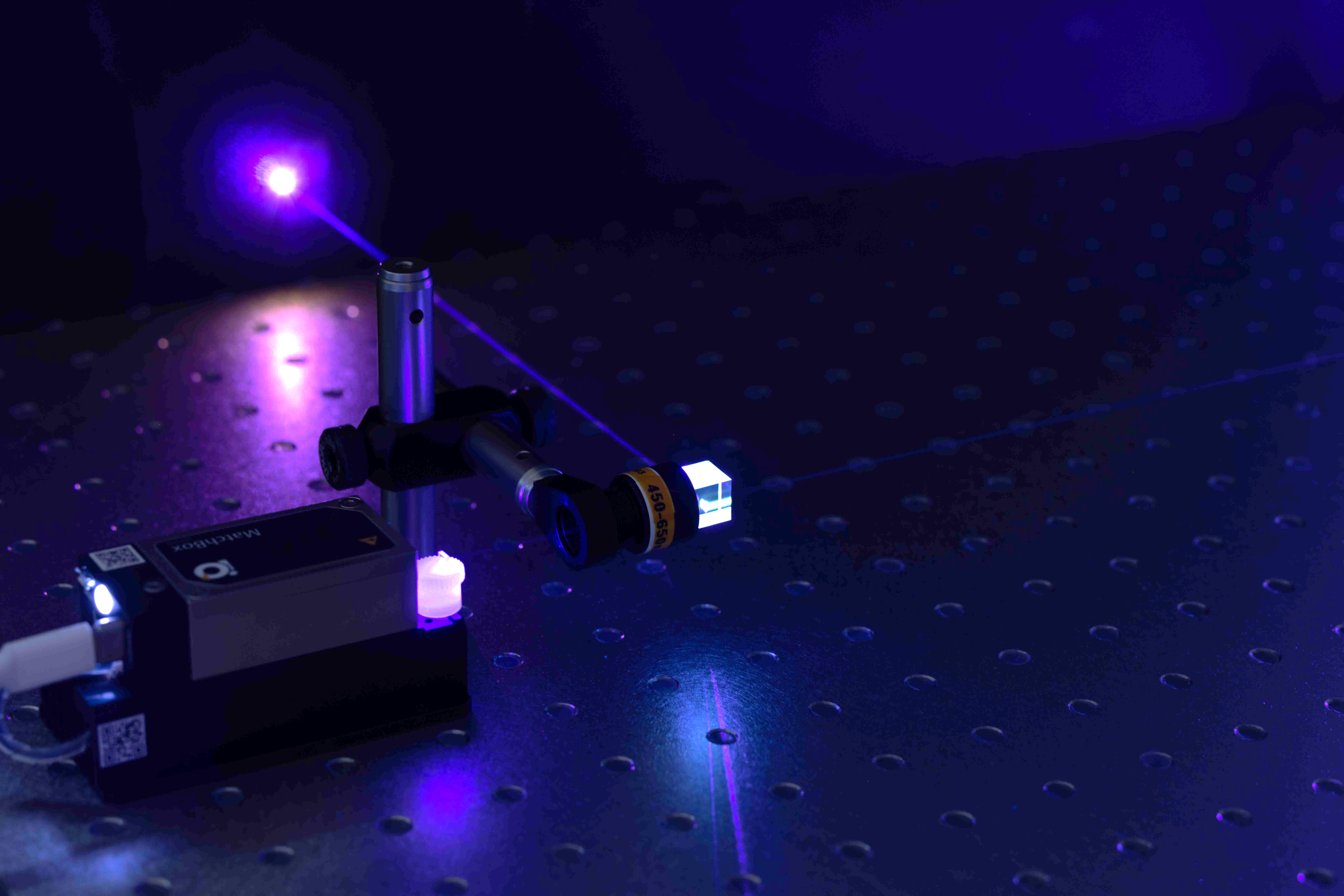A purple laser shooting out from a black device.