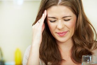 A woman holds her aching head