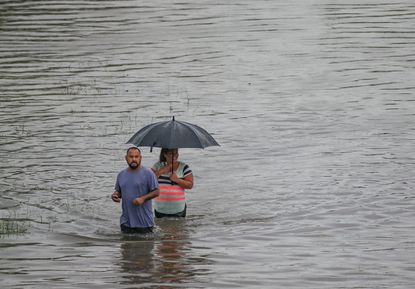 Houston residents walk through floodwaters.