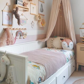 A kids storage day bed with toys and decor displayed on the wall