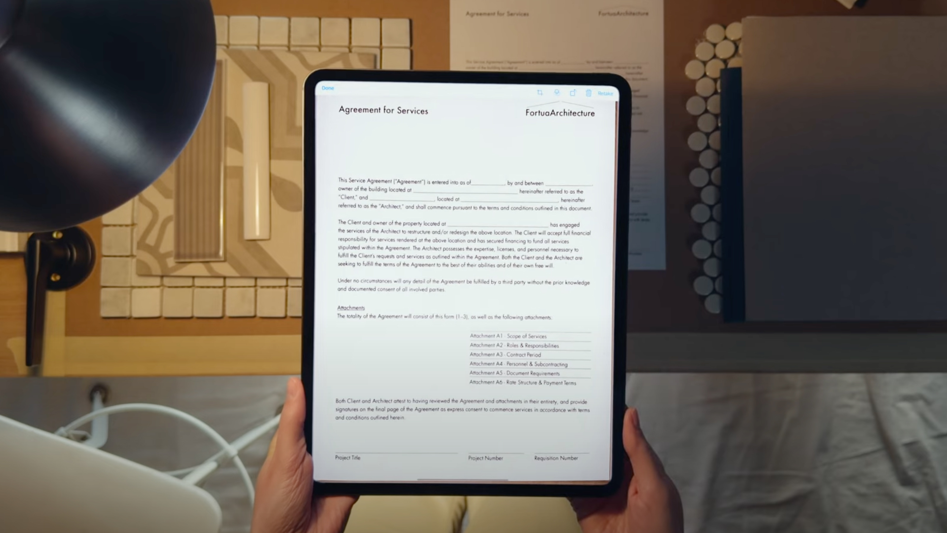 A hand holding an iPad that's scanning a document