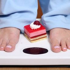 feet on scale with cake between feet
