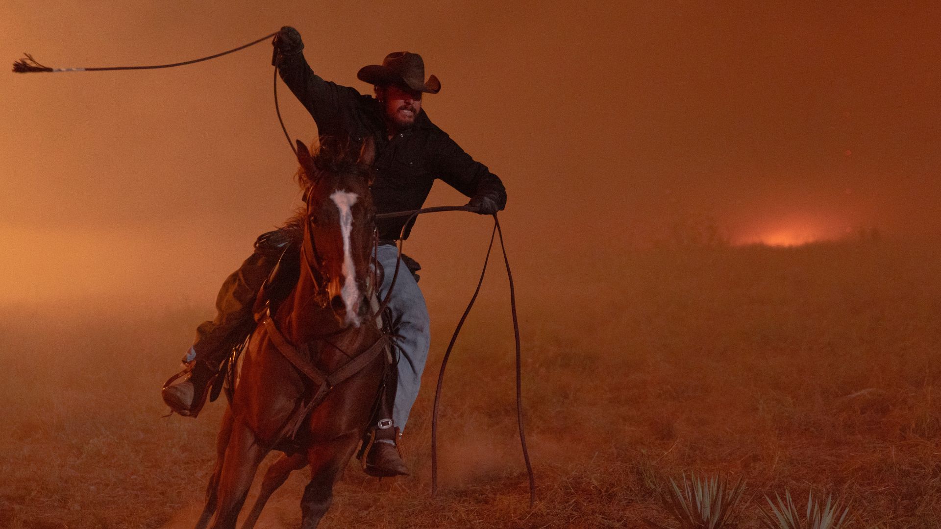 Rip lassos a rope against a fiery backdrop