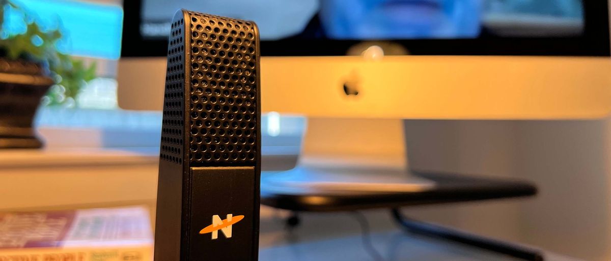 A Neat Skyline microphone on a desk during a conference call